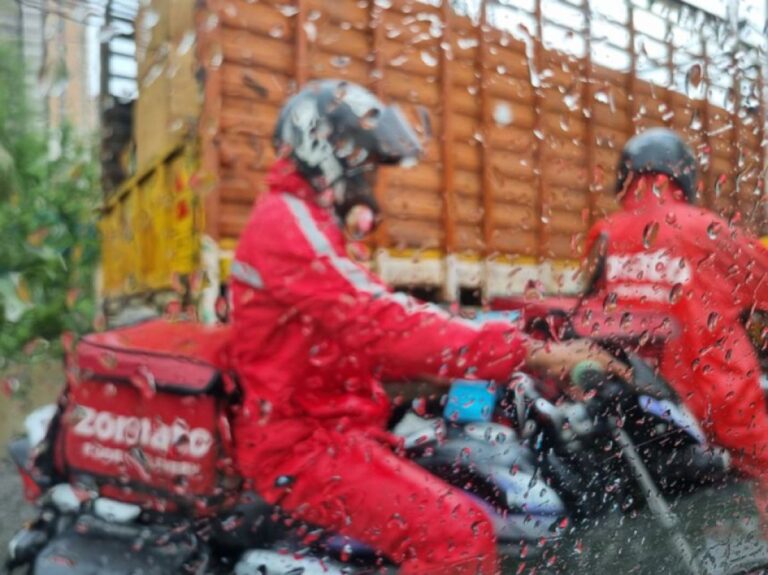 腰まで水につかった状態で冠水した道路を渡り料理を運ぶインドの配達員のど根性