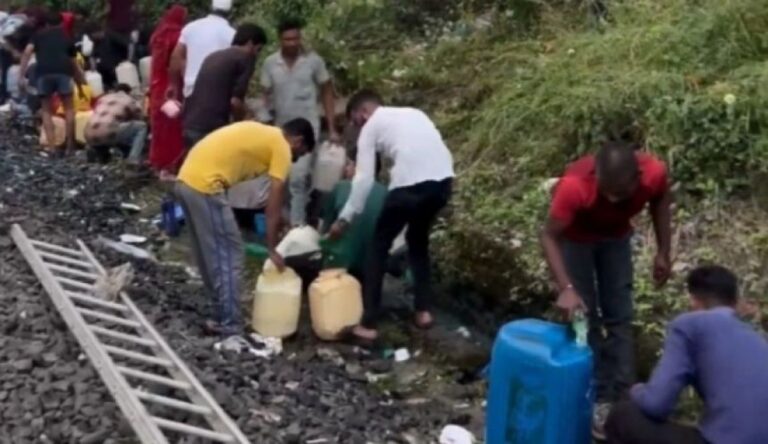 脱線した列車から漏れたディーゼル燃料を容器持参で持ち帰る人々（インド）